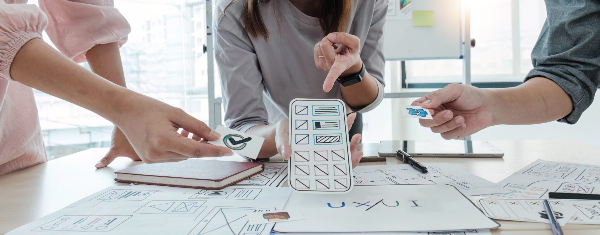 A close-up of an ux ui developer and an ui designer working on a mockup icon interface for a mobile